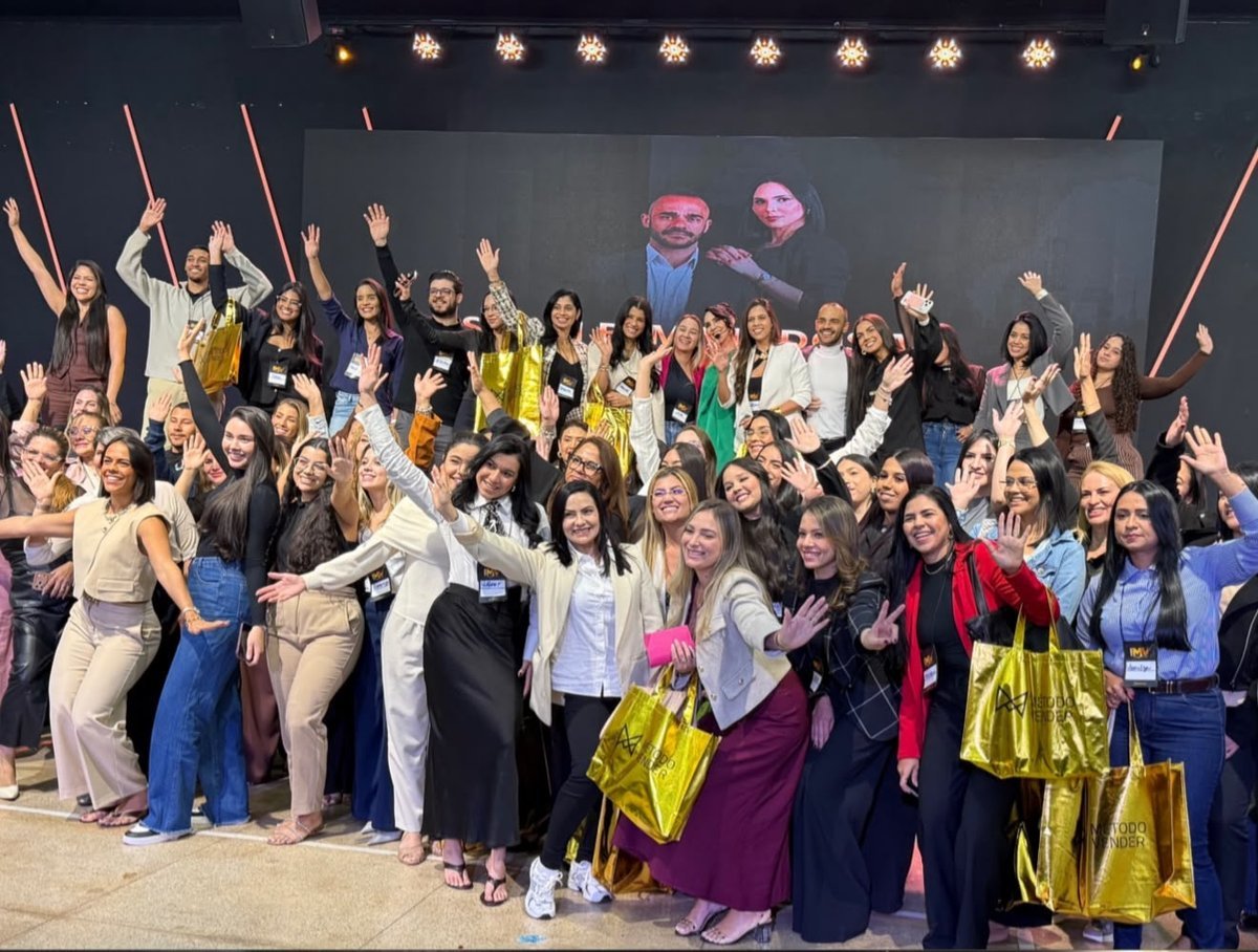 Participantes comemorando no palco da Imersão Método Vender